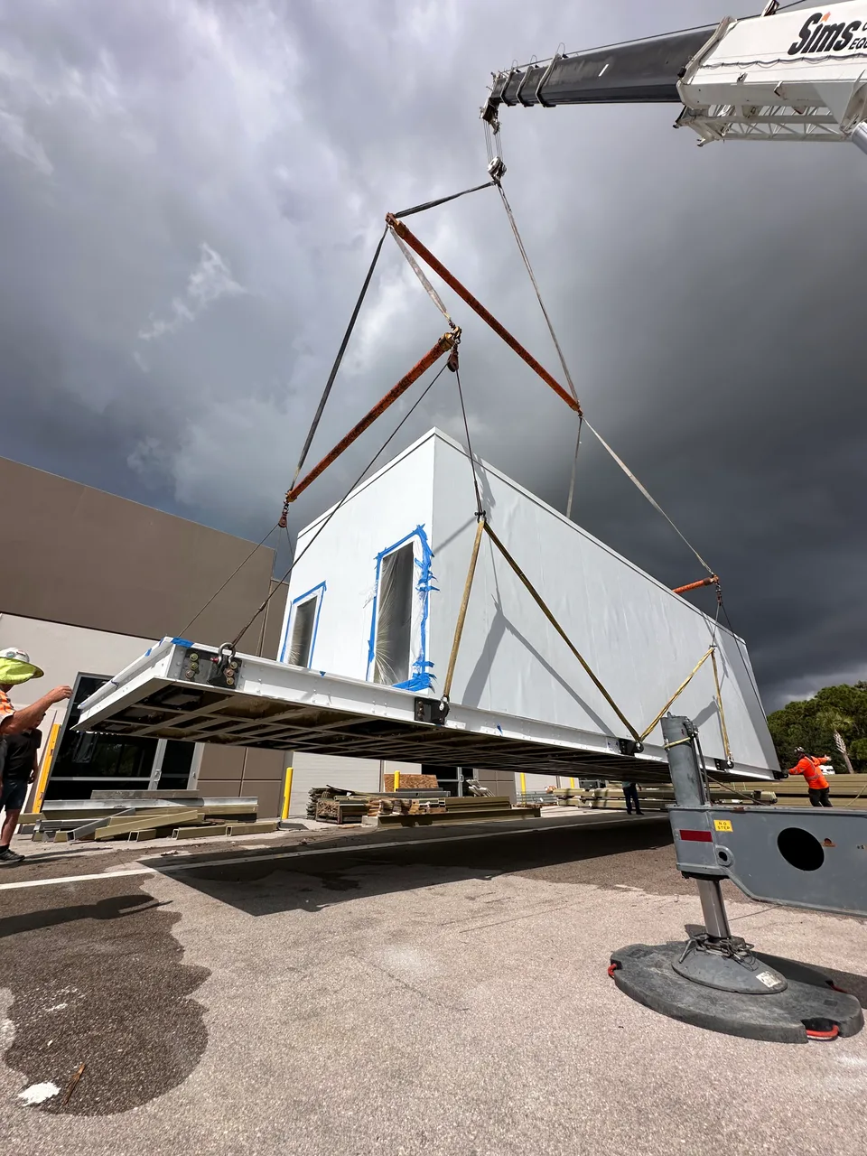 A crane lifting a prefabricated modular data center into position